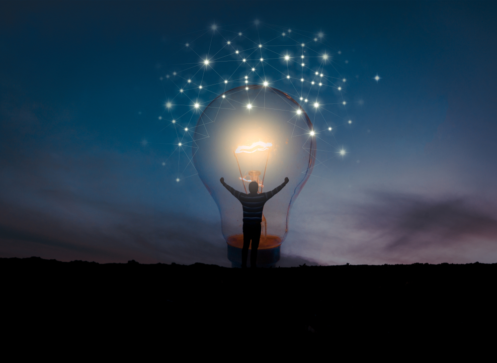 evening sky, man in lit lightbulb, connecting lights floating above